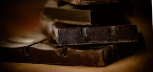 Barretta di cioccolato fondente con etichetta che indica oltre l'85% di cacao, simbolo di salute per il cuore.