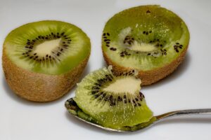 Due kiwi freschi su un tavolo, simbolo del rimedio naturale per la stitichezza.
