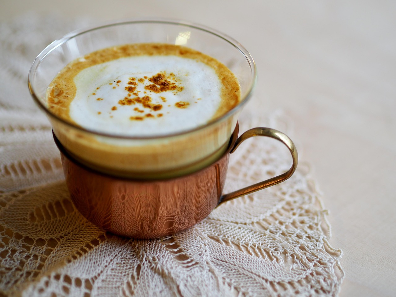 Bevanda di latte d'oro in una tazza, decorata con spezie e curcuma, sul tavolo di legno.